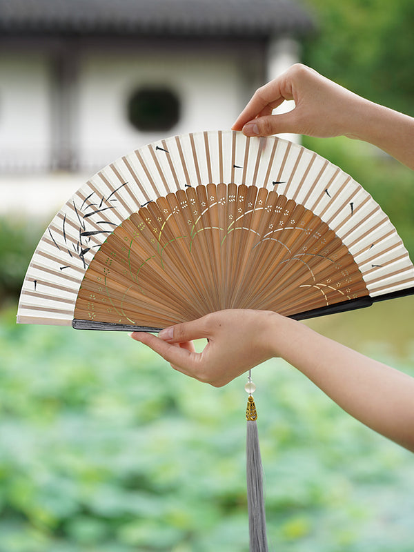 Graceful Folding Fan: Chinese Elegance in Traditional Cheongsam and Dance. Embrace the Ancient Charm of Hanfu with a Touch of Retro Freshness.